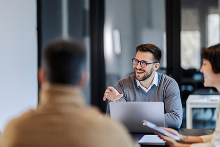 Arbetskollegor i kontorsmiljö diskuterar budgetarbetet.