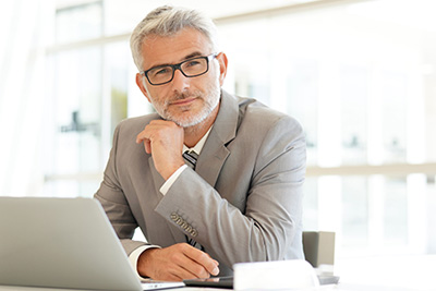 Nöjd man sitter vid dator