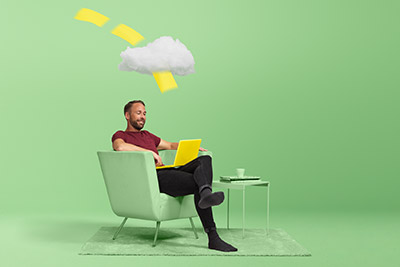 Man sitter i stol och jobbar på en laptop