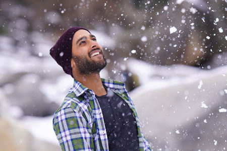 Person njuter av vinterns snöfall och tar till vara på dagsljuset utomhus.